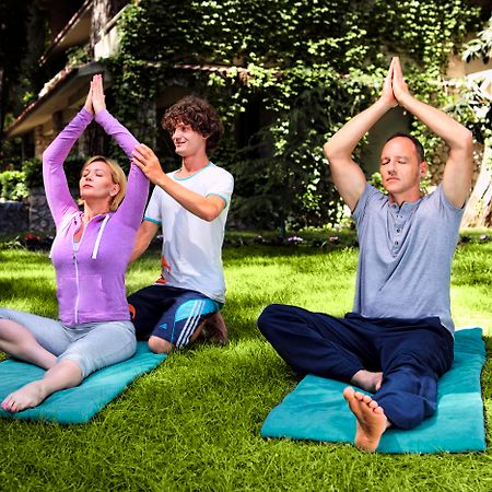 ホテル マート ミラ テキロヴァ エクステリア 写真 A yoga teacher assists students with their practice.